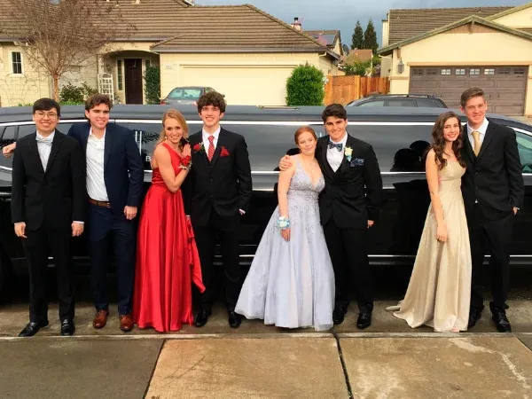 Students in formal wear with black stretch limousine