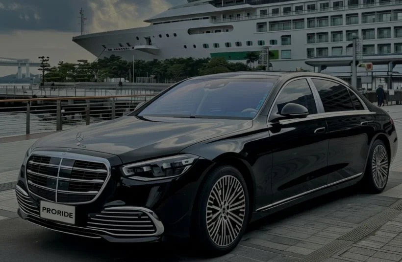 black mercedes sedan parked in front of cruise ship
