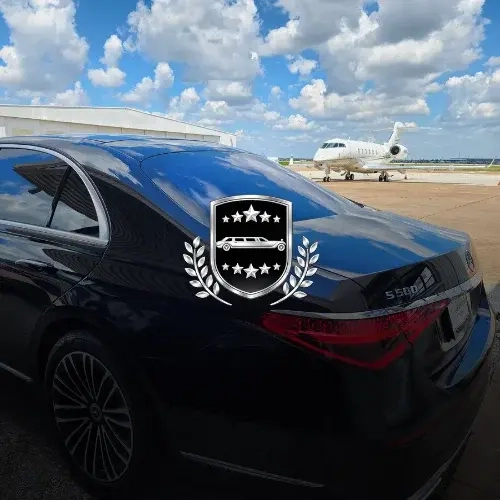 black sedan on tarmac with private jet background