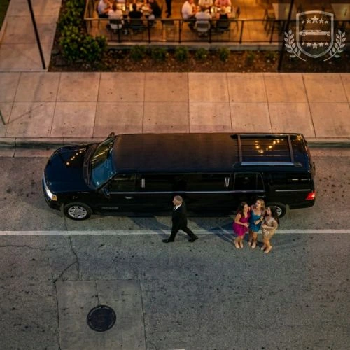 chauffeur walking near a limousine and three women